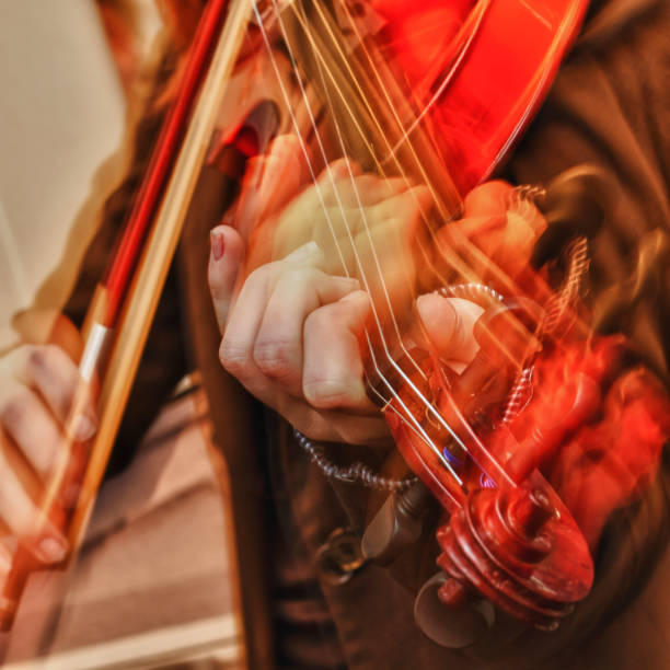 Trace the movement of the hand on a musical instrument here the violin and the fingers of the hand on the strings of the violin