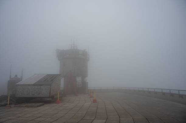 Fog at the top of Mount Washington with view on observation tower t during summer day