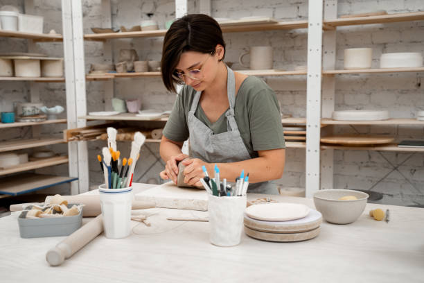 istock Removing air bubbles from clay before modeling to avoid the ruination of a ceramic product. Wedging the clay before starting making a pottery project to create proper consistency. 2163311438