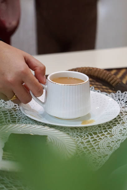 istock A woman holding a cup and saucer. 2163314892