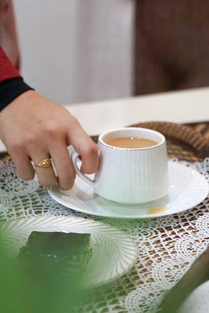 istock A woman holding a cup and saucer. 2163314900