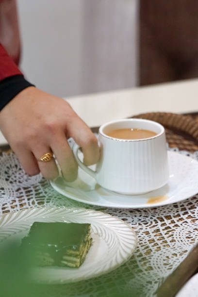 istock A woman holding a cup and saucer. 2163314926