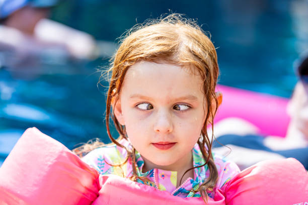 Above shot of teenager girl swimming in the swimming pool and having so much fun on a hot summer day