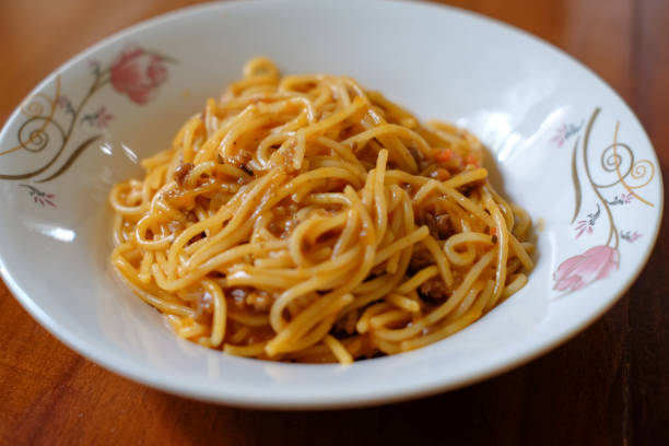 istock Traditional spaghetti bolognese isolated on wood table background 2163323419