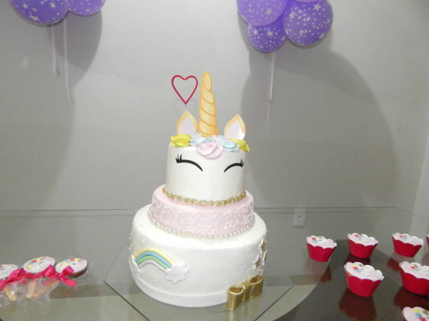 istock Birthday cake with unicorn and rainbow on top, white background. 2163323536