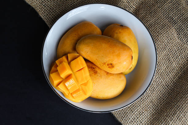 istock Bowl of mangoes on dark background 2163325854
