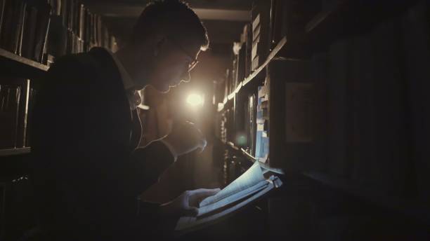 istock Person with gloves looking at papers in the dark 2163329061