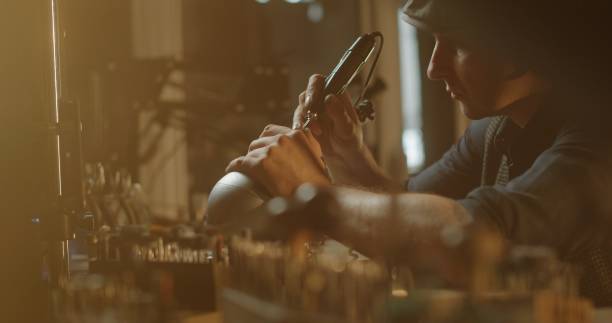 istock Male jeweler using hand drill while making place for gem in ring 2163334575