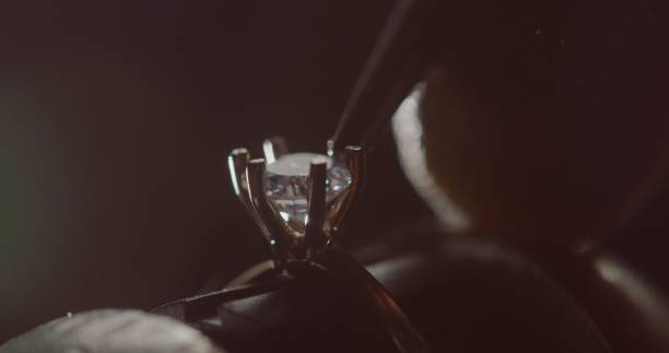 istock Jeweler Setting Precious Gemstone in Ring with Bright Illumination 2163334856