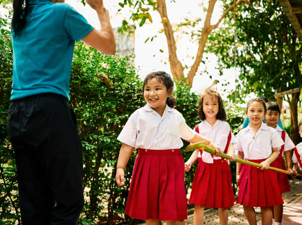 istock School students playing at schoolyard under teacher supervision 2163334924