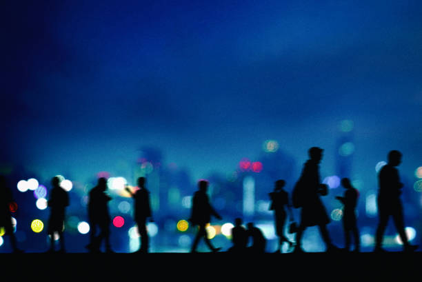 Silhouetted group of people over abstract city lights