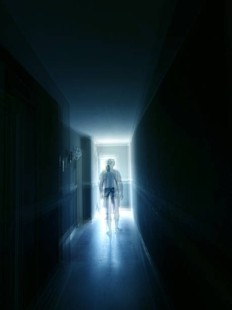 Single man walking in narrow dark corridor in to glowing lights