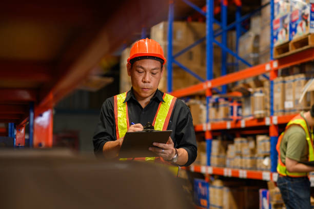 istock Asian man warehouse managers checking stock in workplace warehouse. industry logistic export import distribution concept. 2163349620
