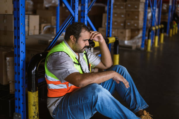 istock Tiredness from hard work concept. Warehouse worker laying on the floor in warehouse after tiring work. 2163349743