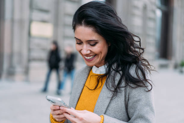 istock Woman using smartphone outdoors. 2163365356