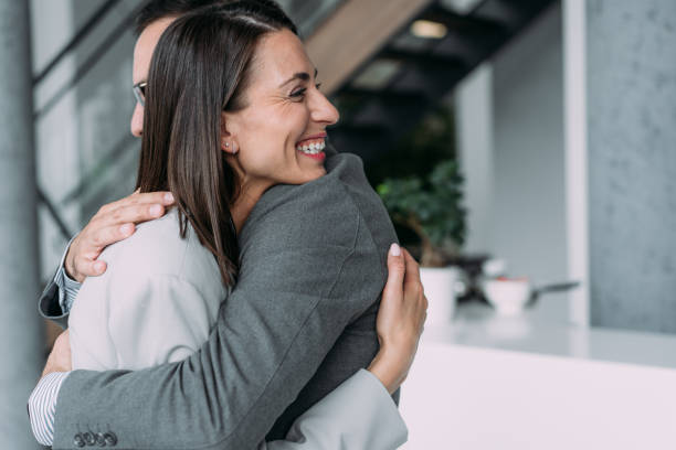 istock Excited coworkers embracing each other during a celebration in the office. 2163365456