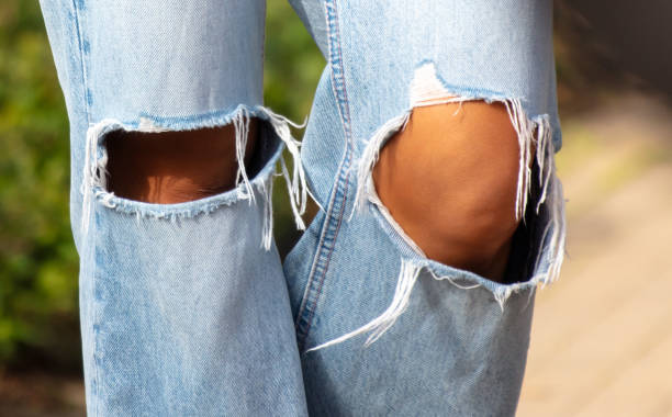 istock Torn jeans on a girl's knees 2163367589
