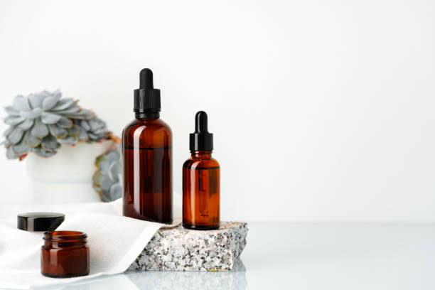 istock Amber Glass Dropper Bottles on Stone Platform With Succulents 2163368591