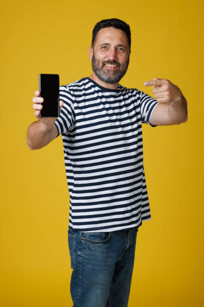 istock Dynamic Portrait handsome man.  Using Smart phone. Striped Blue White Navy T-Shirt, casual lifestyles.  Yellow background. 2163368857