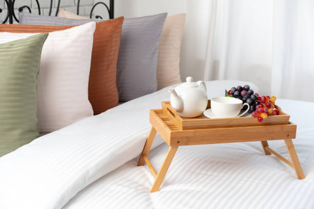 istock Wooden Breakfast Tray With Teapot, Fruit, and Pillows On Bed 2163370918
