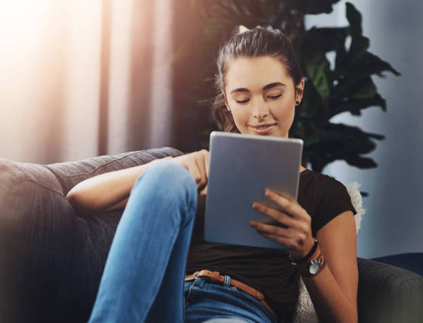 istock Relax, smile and woman with tablet on sofa for communication, network and reading ebook on app. Happy, female person and calm with tech for online story, download and digital literature at home 2163371984