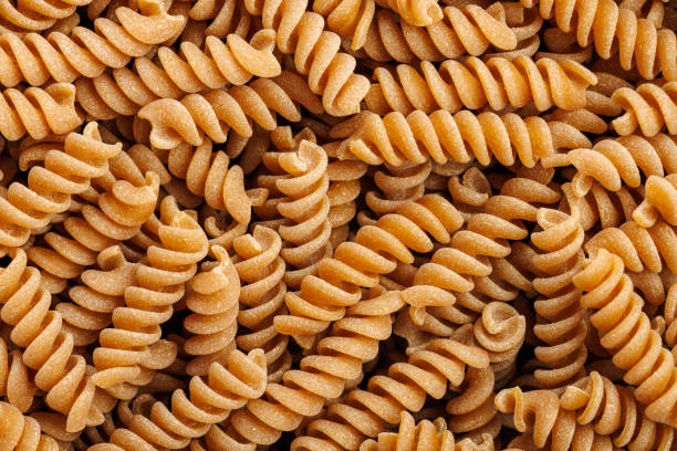 istock Uncooked whole grain fusilli pasta. Top view. 2163372528