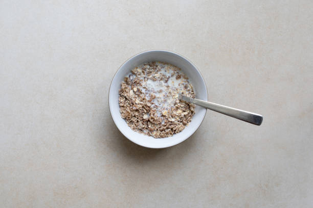 Overhead view of muesli in a breakfast bowl on a plain background