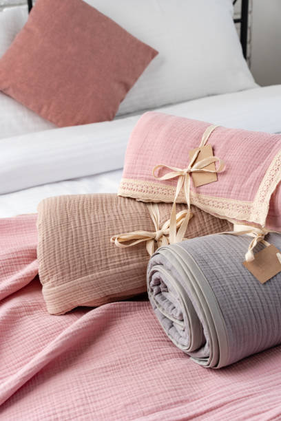 istock Rolled Up Soft Pink and Grey Muslin Blankets on Bed 2163375683