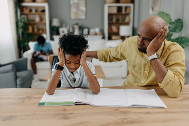 istock Frustrated child and adult discussing homework problems. 2163376126