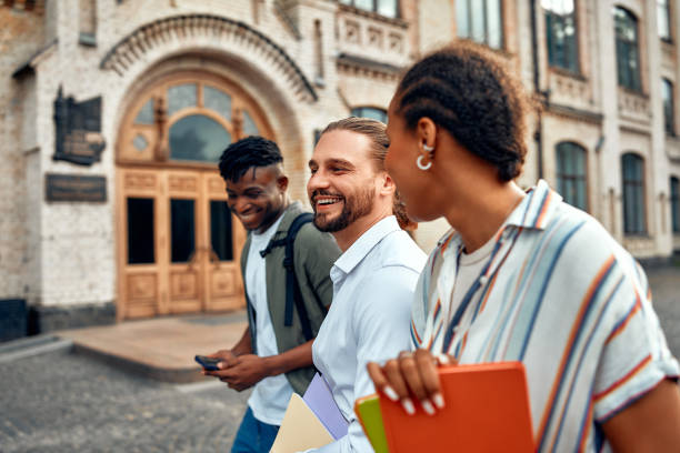 istock A group of university students walking and chatting on campus while carrying books 2163378003