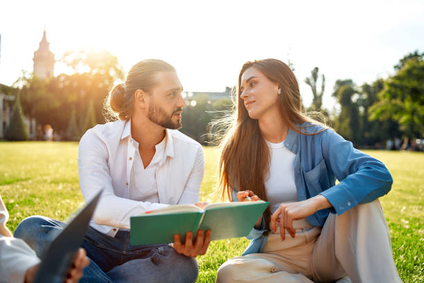 istock A youthful couple is immersed in shared outdoor study time within a park setting 2163378088