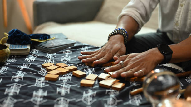 istock Close up hands arranging wooden runes on a table covered with a mystical cloth. Forecasting and divination concept 2163381537
