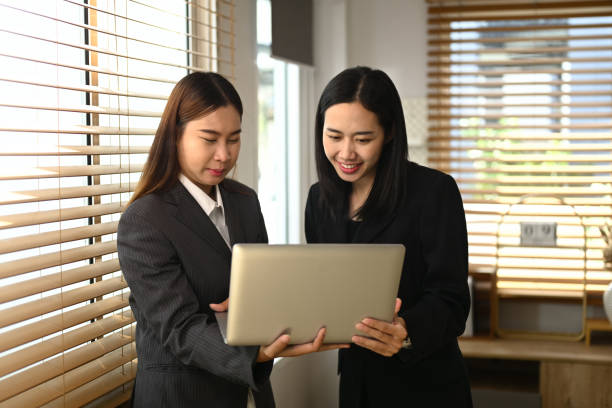 Two businesswomen collaborating in a modern office. Teamwork and collaboration themes concept Two businesswomen collaborating in a modern office. Teamwork and collaboration themes concept. strategic themes stock pictures, royalty-free photos & images