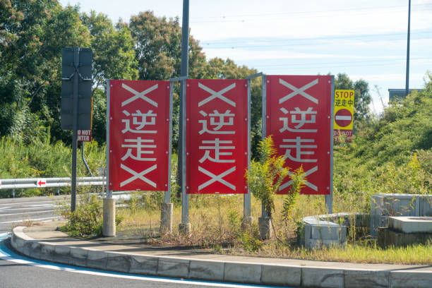 A warning sign for wrong-way driving on a highway, written in Japanese as \