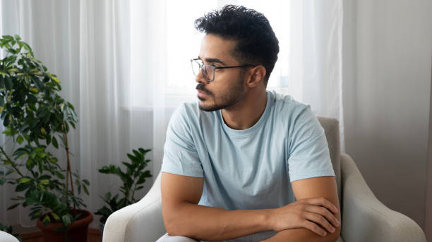 istock Man in glasses looks thoughtful while sitting at home 2163383161