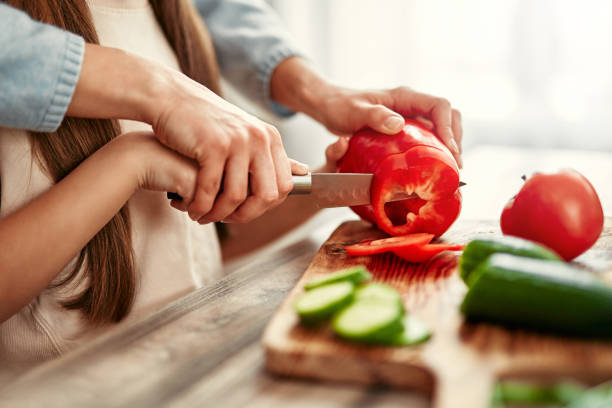 istock Father and child cooking together, preparing fresh vegetables for a nutritious meal 2163384673