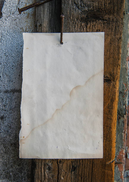istock Old vintage paper advertisement hanging on aged wall 2163392878
