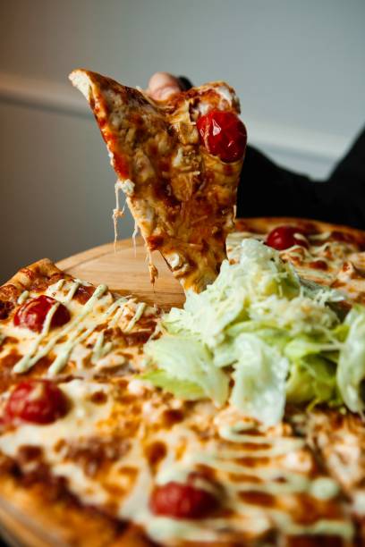 istock Pizza Slice Being Taken From A Large Pizza 2163393064