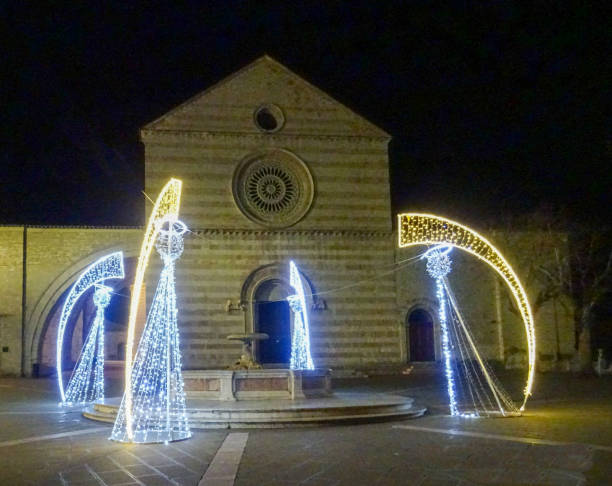 Nativity scene made with Christmas lights in front of the old Basilica di Santa Chiara in Assisi. The Basilica was built next to the ancient church of San Giorgio, the place of the first burial of both San Francesco in 1226 and Santa Chiara in 1253. It was consecrated in 1265. In addition to the body of the Saint, it houses the Crucifix of San Damiano that spoke to San Francesco.Nativity scene made with Christmas lights