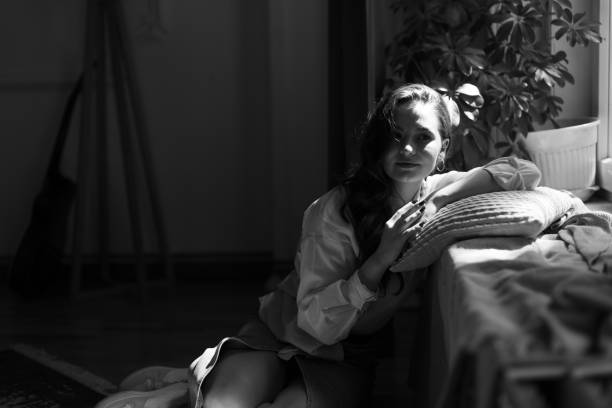 girl on a white background in white clothes on a white chair smiling
