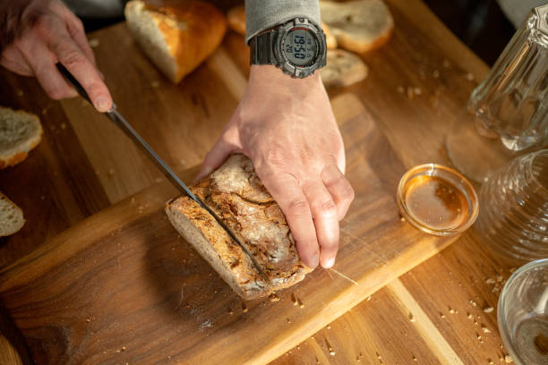 istock Slicing Fresh Bread on Wooden Board in Home Kitchen 2163396885