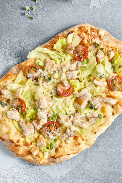 istock Caesar-Style Pinza with Chicken Fillet and Cherry Tomatoes on Rustic Stone Background 2163400290