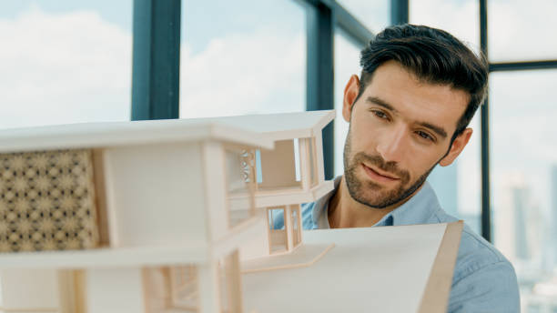 istock Engineer turns house model left and right to check mistake point. Tracery 2163401807