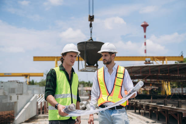 istock Engineers discussing building plans at a construction site. The construction manager and engineer are collaborating on the project. 2163410464