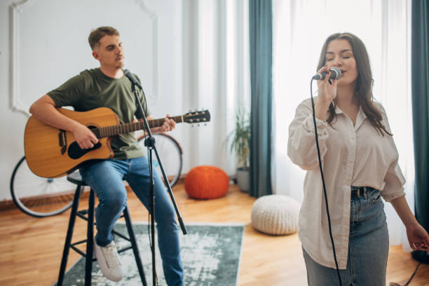 istock Female singer enjoying performance with guitarist duo behind 2163412295