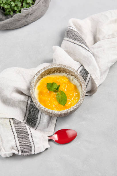 istock Delicious Mango Panna Cotta Dessert in Rustic Bowl with Fresh Mint Garnish 2163413109