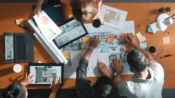 istock Top down view of engineer handed document while looking at blueprint. Symposium. 2163414625