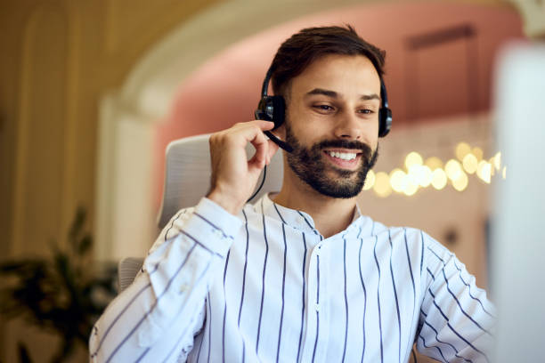 istock A smiling man talking to someone, working as an operator, on a call line. 2163415440