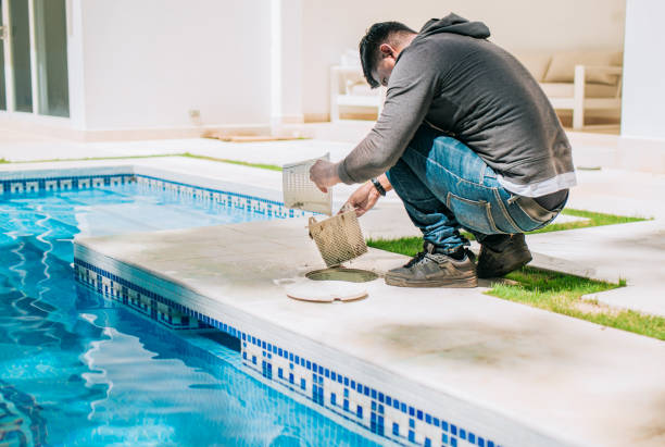 istock Man cleaning swimming pool garbage filter. Worker removing trash from swimming pool filter basket 2163416249