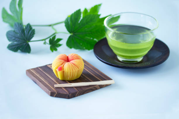 Summer Japanese sweets and cold green tea and raspberry leaves with white background.
